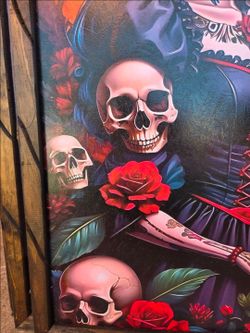 A frame depicting a woman styled as the Day of the Dead's La Catrina, surrounded by skulls and red roses.