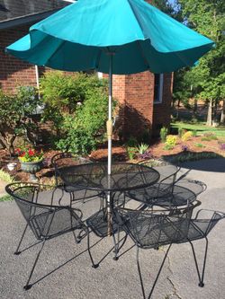 Iron table with four chairs and umbrella