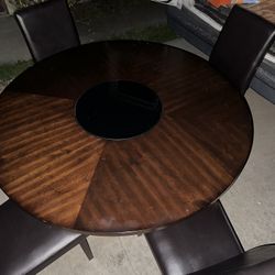 55”  Round Dining Table with Lazy Susan And 4 Leather Chair One of the chair  is damage ( check actual Pictures) Table has scratches from usage ( chec