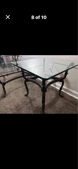 A three piece thick glass living room set with a bronze frame .