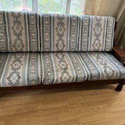 Vintage Dark Solid Wood Couch With Three Navajo Pattern Cushions.