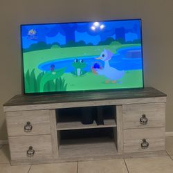 60 inch smart TV great condition plus TV stand from Ashley’s furniture