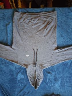 Comfortable Nike hoodie in charcoal grey. This garment has a front kangaroo pocket, a drawstring hood, and the brand logo on the chest.