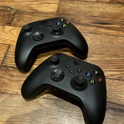 Pair of black Xbox controllers