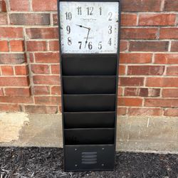 industrial-style black iron wall clock with built-in storage