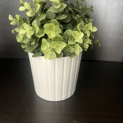 White vase with green fake plants
