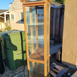 wood floor standing curio cabinet with glass shelves.  used as is