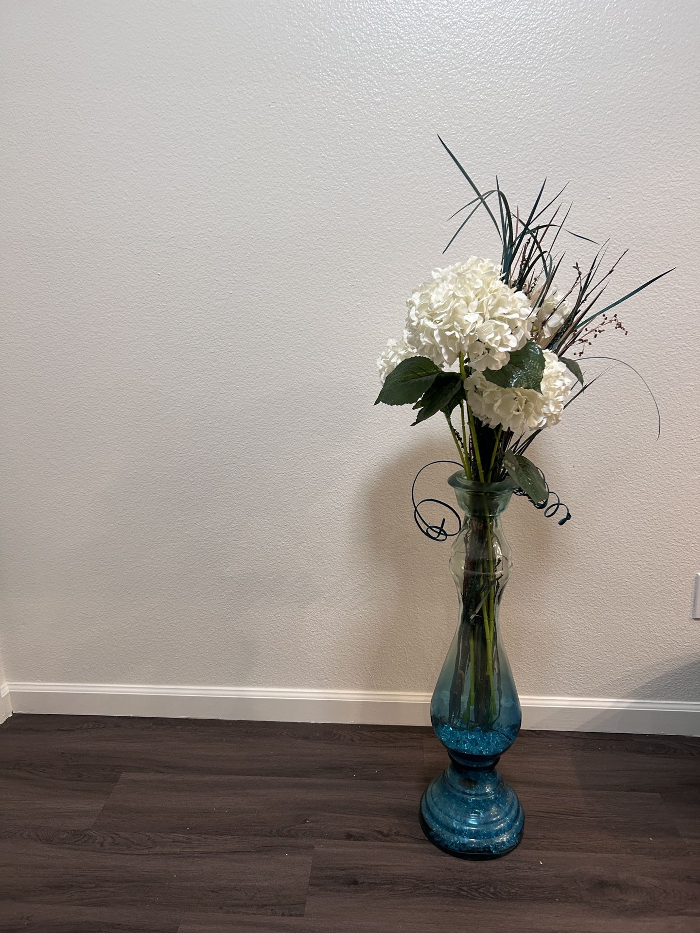 Vase With Fake Plants And Blue Pebbles