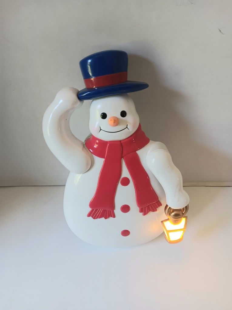Mr. Christmas animated light up moving hat tipping snowman door / wall decor. Tested and works. Scensored. Battery operated.
Snow man rocks back and
