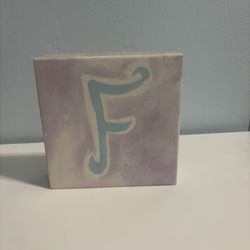 Small canvas art featuring a large letter F in pastel colors.