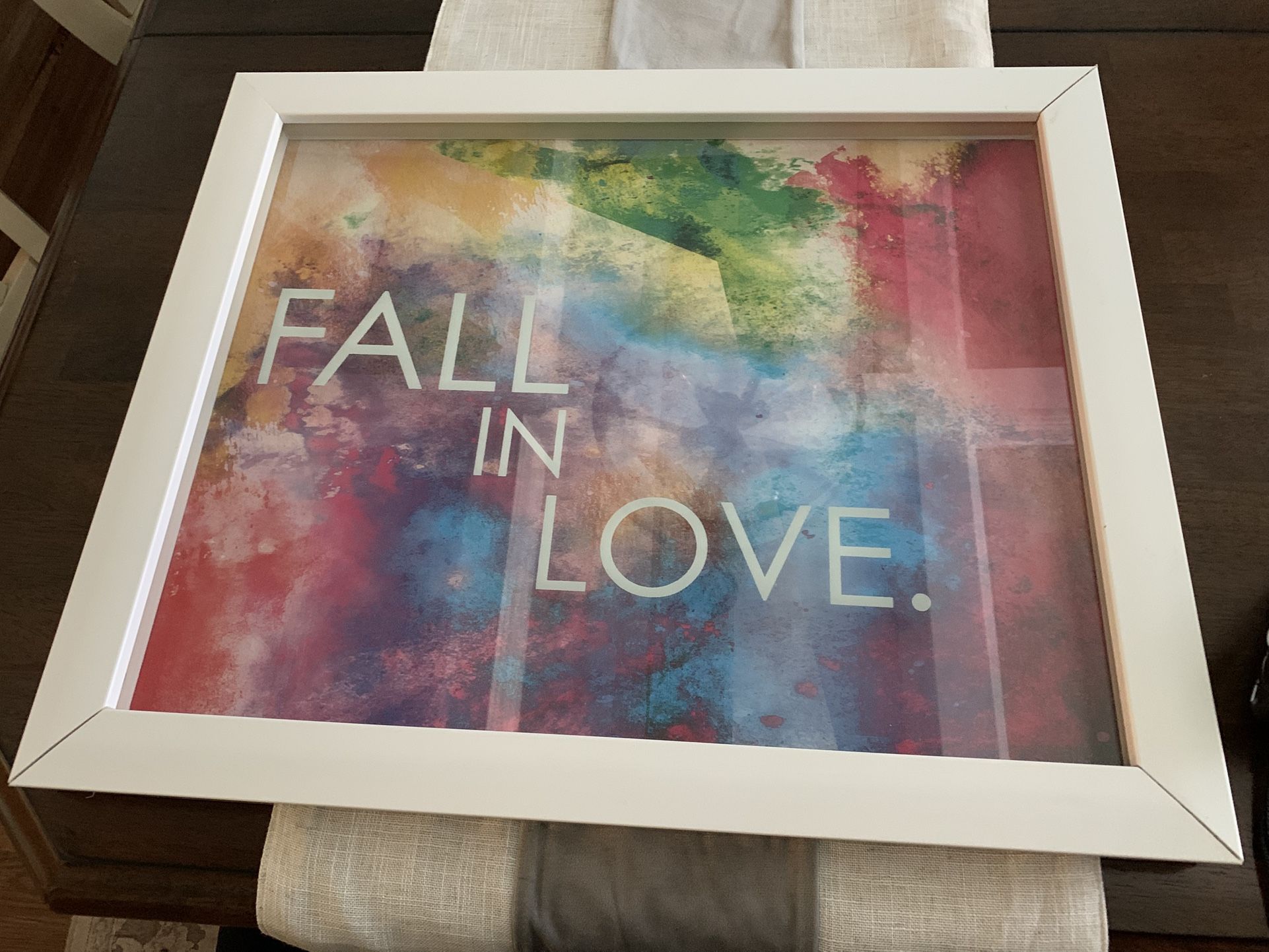 19 By 22.5 Inches Framed Artwork W/ Saying Fall In Love, White Thick Plastic Frame, Clear Cover Has Saying Floating Over Color Background