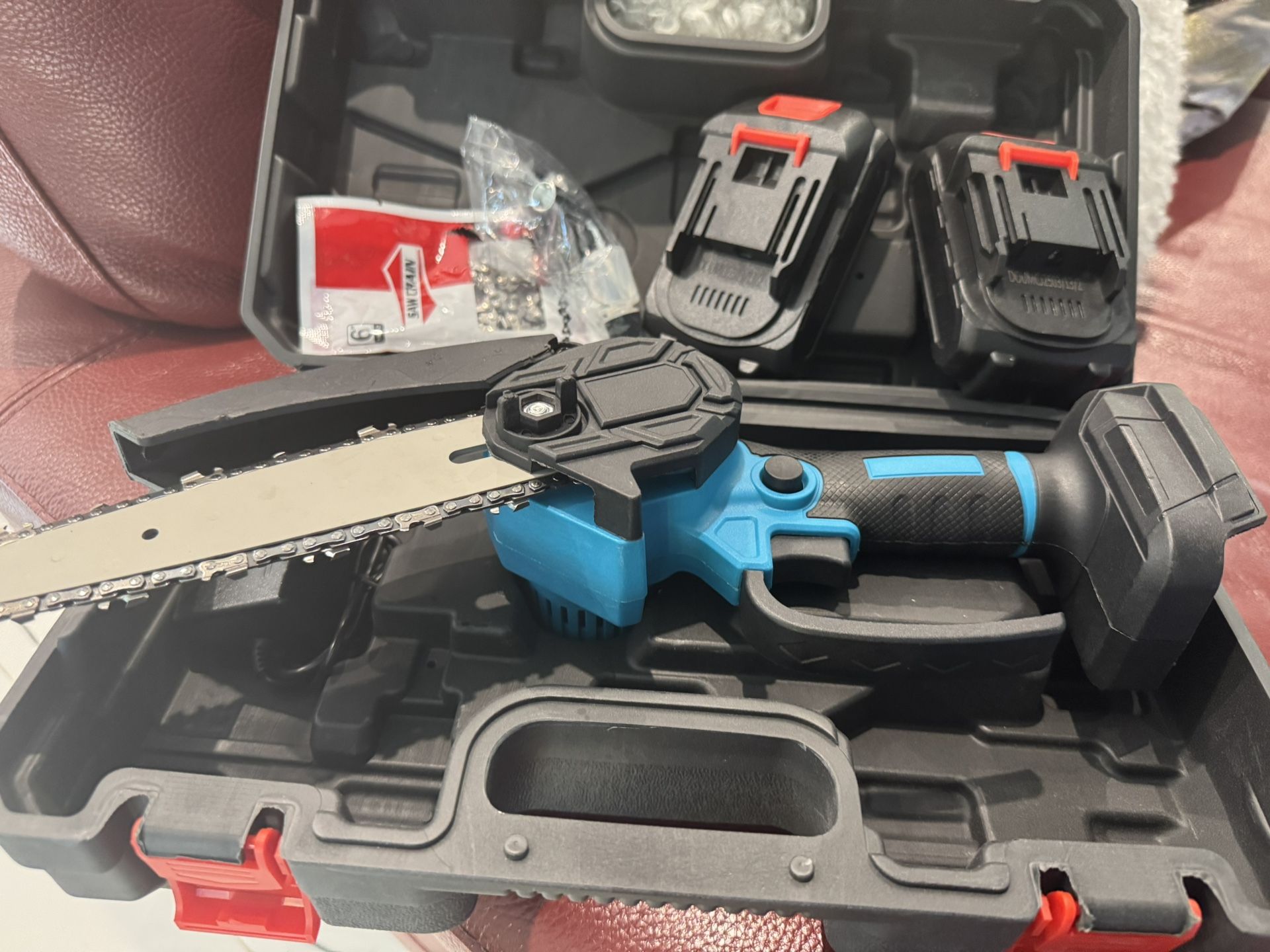 Mini motosierra nueva en caja con 2 baterías, cargador y 2 cadenas