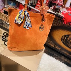 “Michael Kors orange suede tote bag. Very clean inside and out, gently used and well taken care of. Soft suede with leather straps and MK charm. Large