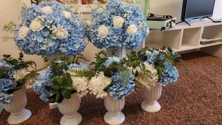 Blue floral arrangement in white vase