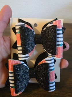 glittery black and patterned layered hair bow designed with a built-in clip for easy styling.
