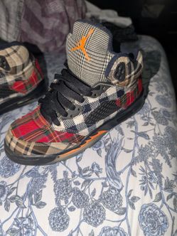 This is a pair of Nike Air Jordan 5 Retro Plaid sneakers in a kids' exclusive colorway featuring a multicolored tartan textile upper.