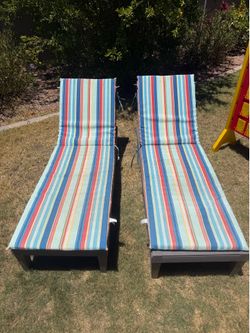 Two lounge chairs with striped cushions.
