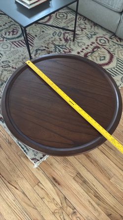 Round walnut colored coffee table.