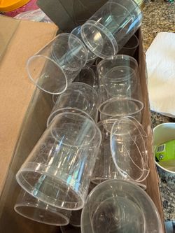 Box full of clear plastic round cylindrical containers