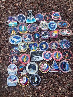 collection of vintage NASA space shuttle mission patches and commemorative stickers
