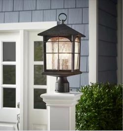 Weather-resistant outdoor post lantern has a dark bronze finish with seeded glass panels. This light fixture is constructed from metal and features a 