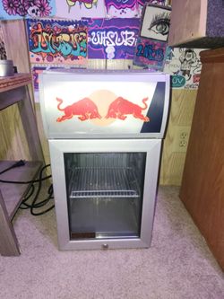Red Bull "Baby Cooler" mini fridge with a silver finish and a glass display door.