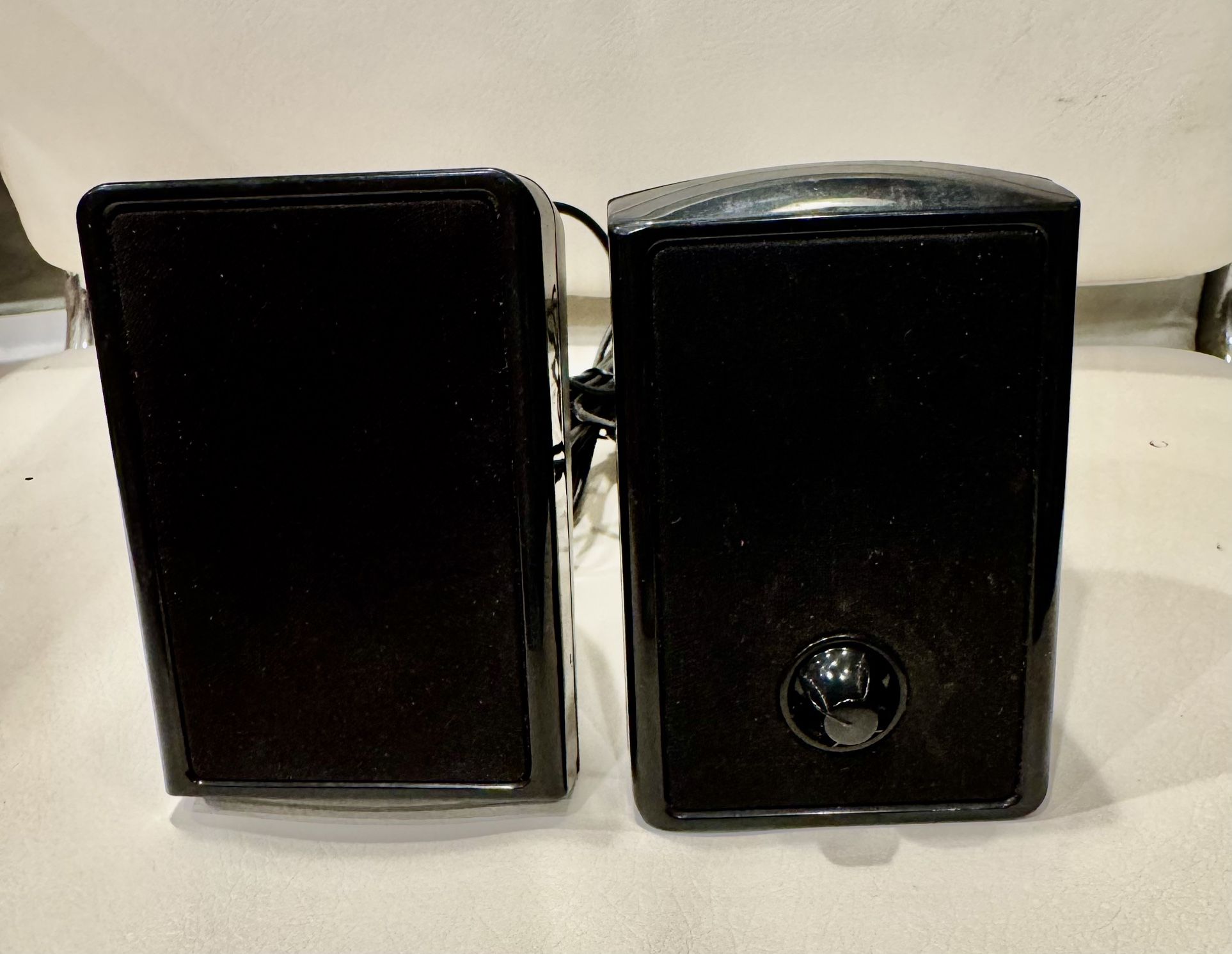 a pair of small, wired computer speakers.