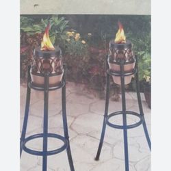 Two tiki oil lamps, and two containers of oil