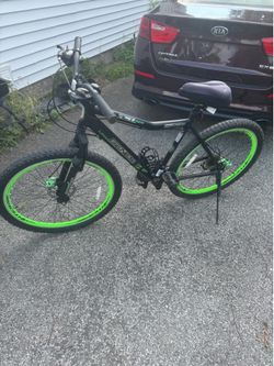 This is a Genesis RCT mountain bike featuring a 27.5-inch aluminum frame and distinct green rims.