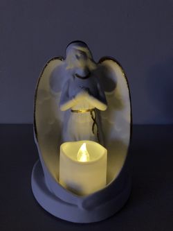 NEW! Lovely Angel Figurine Tea Light from Hallmark. This porcelain angel figurine has wings outstretched and folded around a tea light holder to cast 