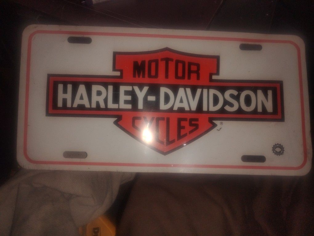 It is a vintage-style license plate featuring the classic Harley-Davidson logo.