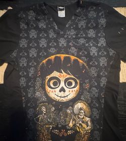 Medium Nurse Scrub Disney Coco black cotton, polyester & spandex shirt with graphic of a large skull with two smaller skeletons playing instruments, s