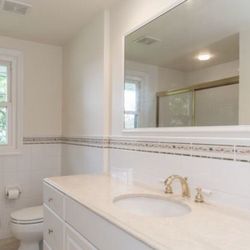 bathroom sink with marble counter top and 6 wooden drawers 