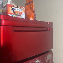 Red laundry pedestal with a storage drawer
