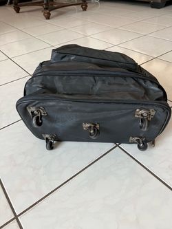 5-wheeled case in good condition, featuring various zippers to expand or reduce its size.