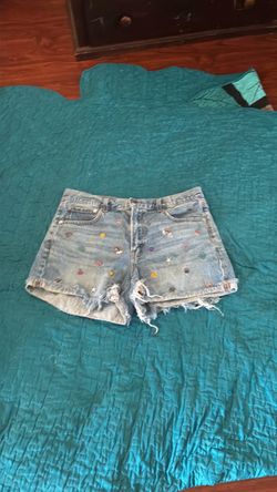 Light Wash Denim Cutoff Shorts with designs on them
