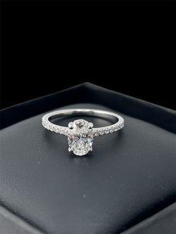 Oval-cut diamond engagement ring featuring a petite pave band in white gold