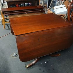 Antique Wood Table With Metal Feet And Drop Leaf On Each End To Make It Smaller And 4 Leafs To Extend The Middle To Make It Longer 