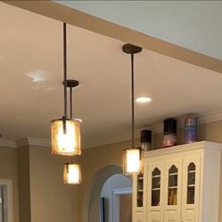 Three handblown pendant lights, amber color. 36”