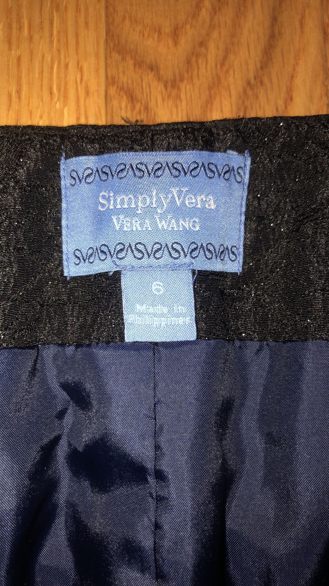 Vera Wang size 6 black lace pencil skirt with a navy ribbon & bow at the waist and has a slit in the back. Zips up the side