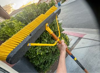 Quickie Jobsite 24-inch Multi-Surface Indoor/Outdoor Push Broom featuring a built-in scraper blade on the front edge for removing tough, stuck-on dirt