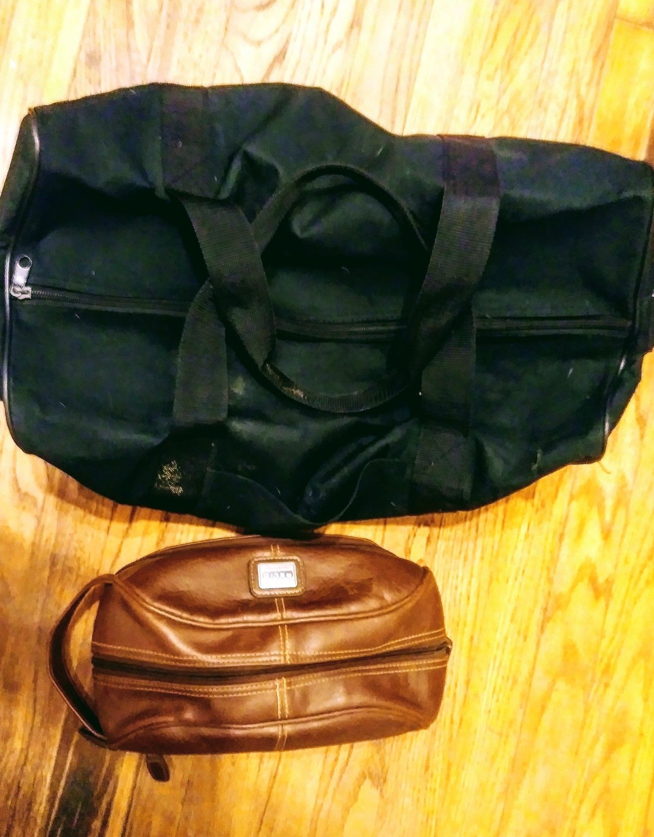 Men's large black duffle bag and men's brown leather personal items travel bag
