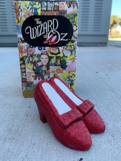 The Wizard of Oz ruby red slippers decorative ring holder with a sparkly red glitter finish and white inner lining.