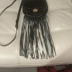 Stylish black crossbody bag with fringe detailing. Perfect for adding a chic touch to any outfit.