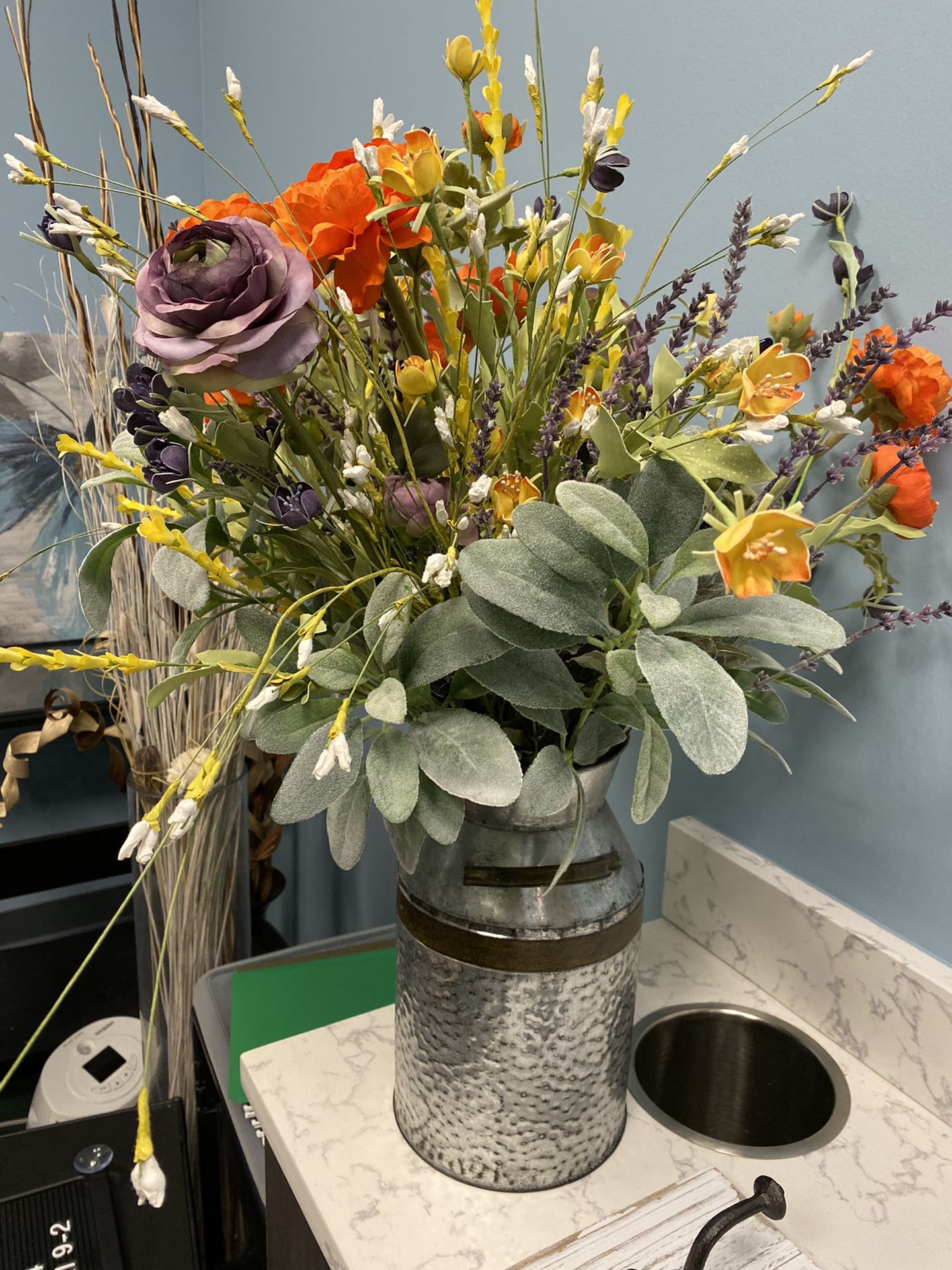 Set of faux flower arrangements in milk tin vases