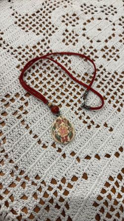 a necklace with a carved pendant featuring two roosters and a Chinese "double happiness" symbol.