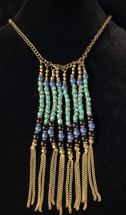 $10. Tassel fringe brass colored necklace with various blue glass beads. Necklace is 18 in. Tassel is 5 in Long and 2 inches wide.