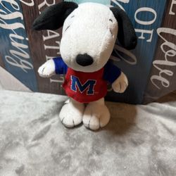 A plush snoopy toy wearing red shirt
