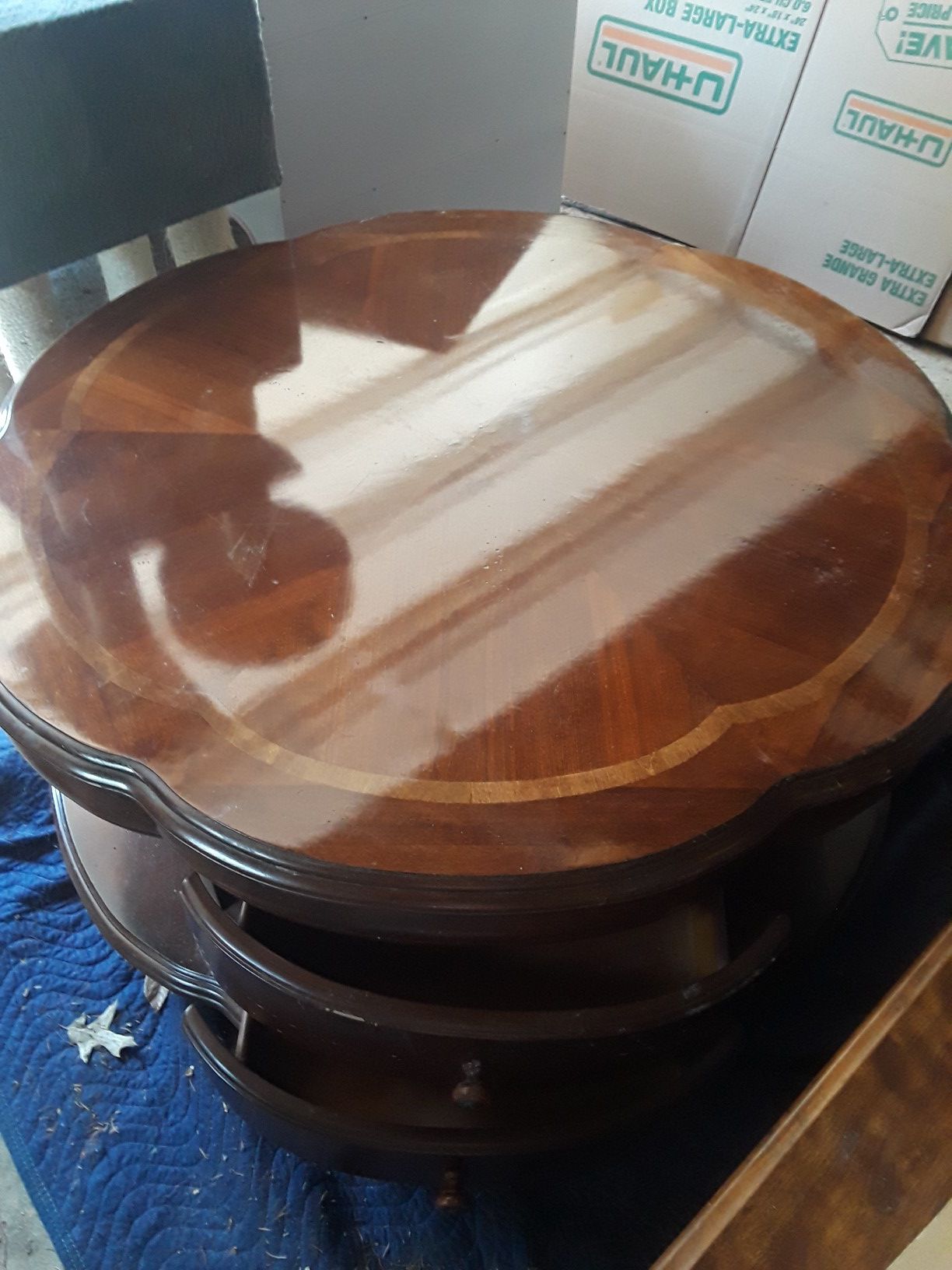 Round wood coffee table with drawers and shelf