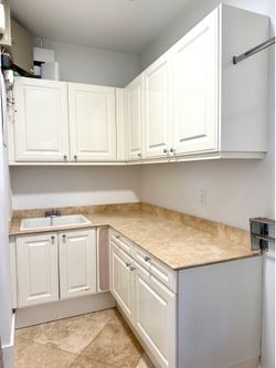 Laundry room cabinet set by Poggenpohl (high-end German cabinetry brand) in a classic cream white shaker finish.